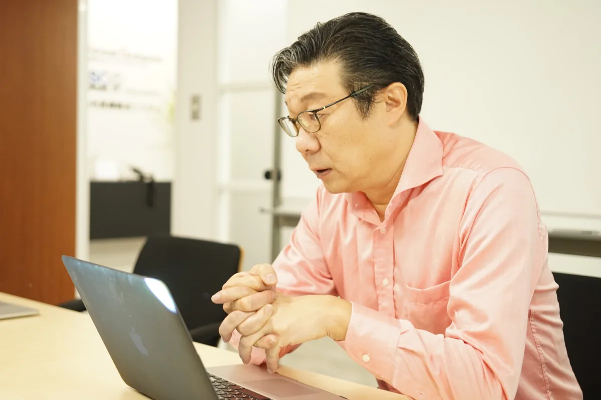 ノートPCに向かって話す代表取締役 黒澤 宏亮