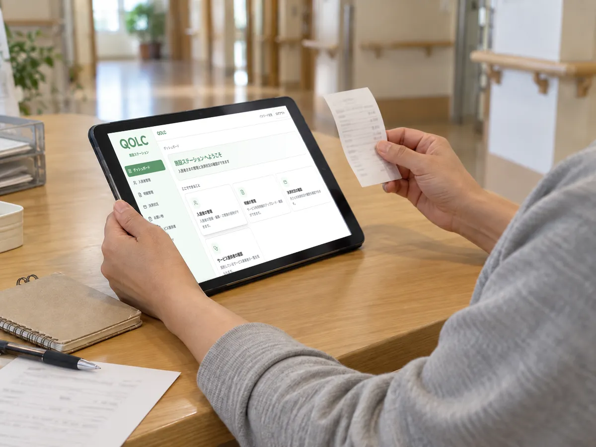 介護施設で、職員がタブレットのQOLCの画面とレシートを確認する手元